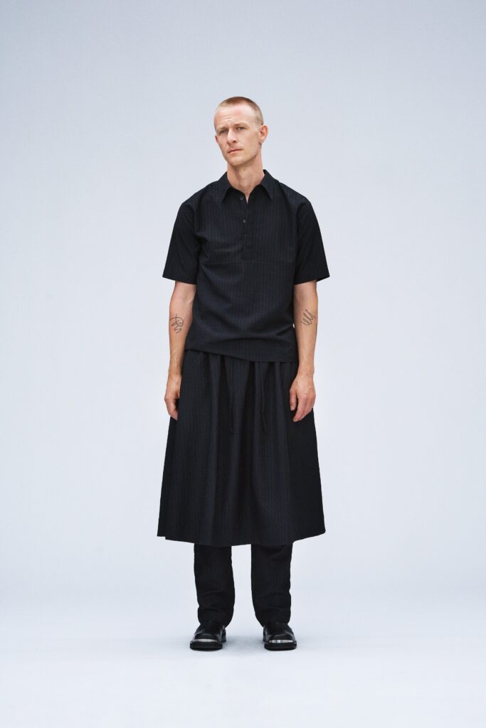 black relaxed shirt and pleated skirt