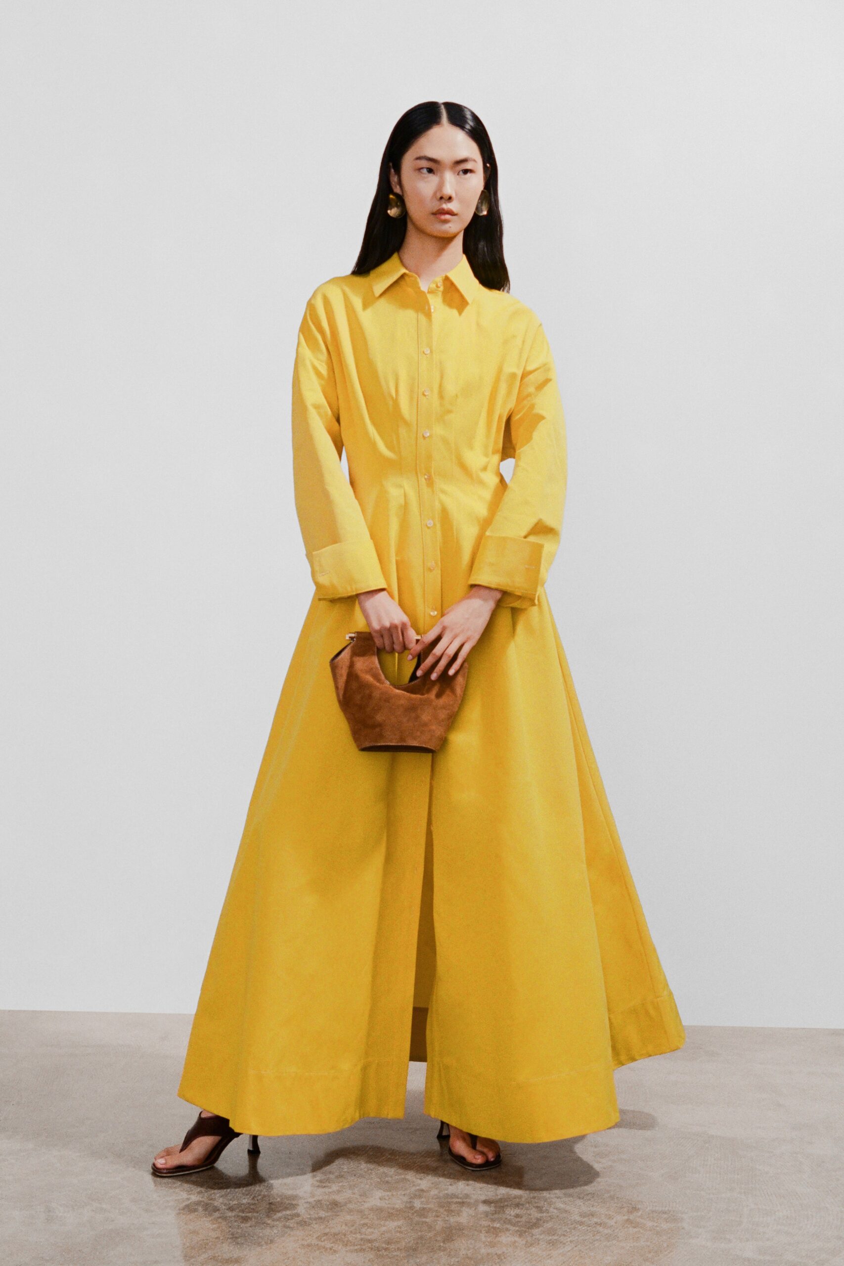 A relaxed yellow cotton long-sleeve dress with a collared neckline and maxi silhouette.