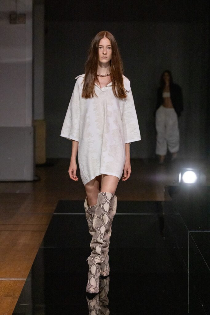 A relaxed white dress with short sleeves and a collared neckline, featuring a straight-leg silhouette.