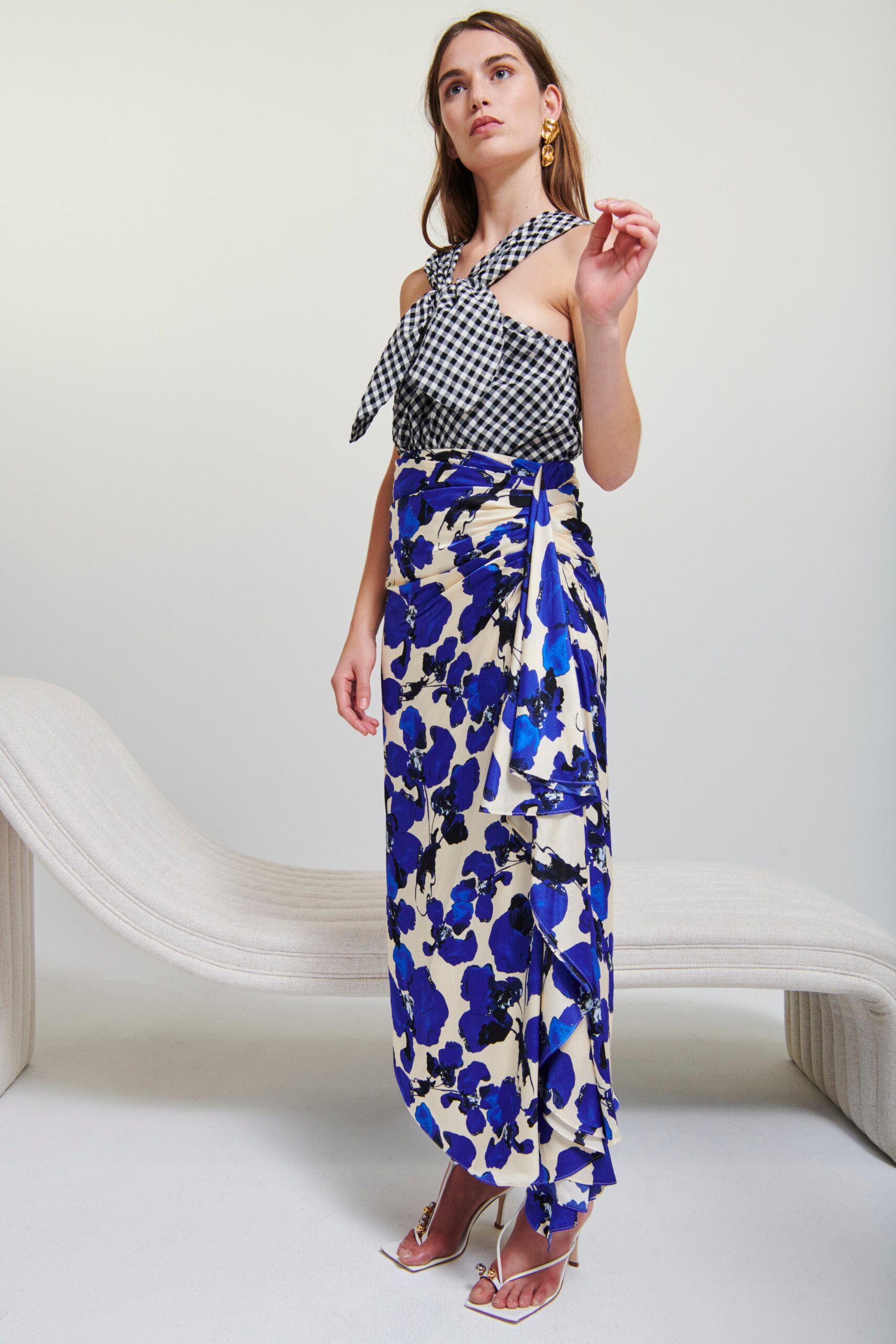 A fitted sleeveless checked top paired with a floral skirt, creating a stylish ensemble.