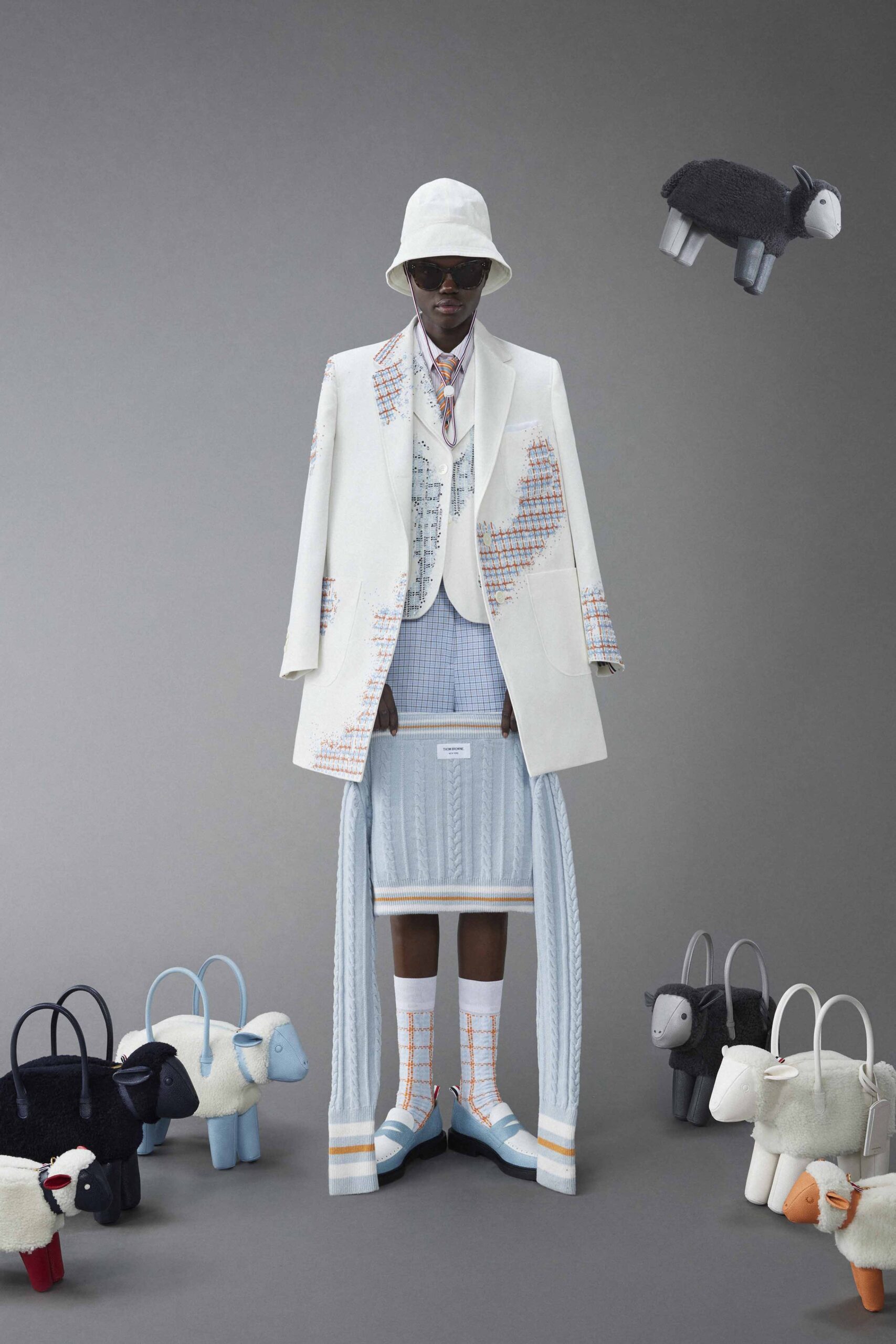 A structured white suit with a layered asymmetric skirt in blue tones.