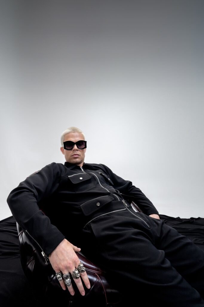A fitted black cotton jacket with long sleeves and zippered details paired with matching pants.