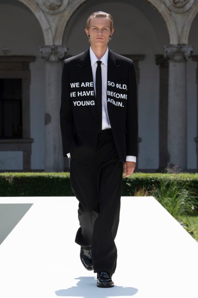 A tailored black suit with long sleeves and a collared shirt, featuring a buttoned design.