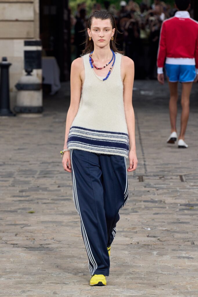 A relaxed beige sleeveless top paired with navy striped pants for a casual look.