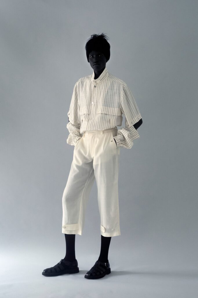 A relaxed white cotton long-sleeve collared shirt paired with relaxed-fit pants featuring a striped pattern.