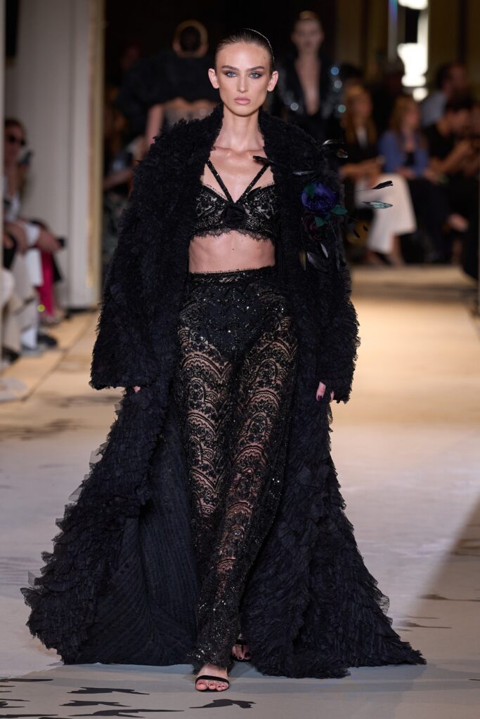 A fitted black lace dress with a V-neckline, layered design, and a matching coat.