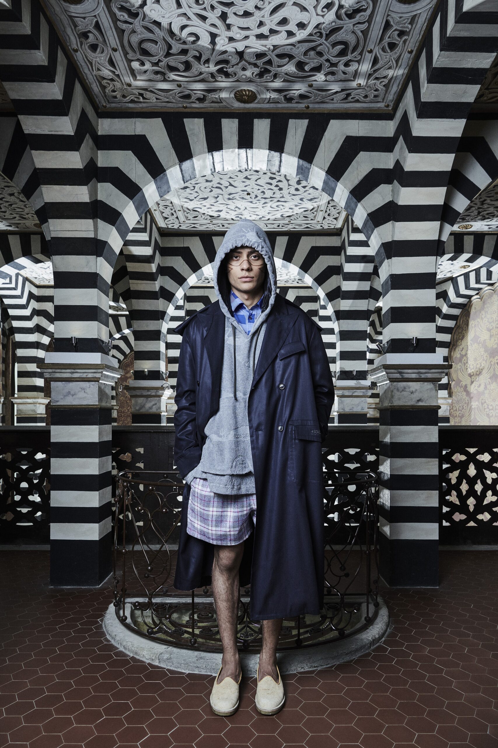 A relaxed black coat layered over a gray hoodie, featuring a hood and long sleeves.