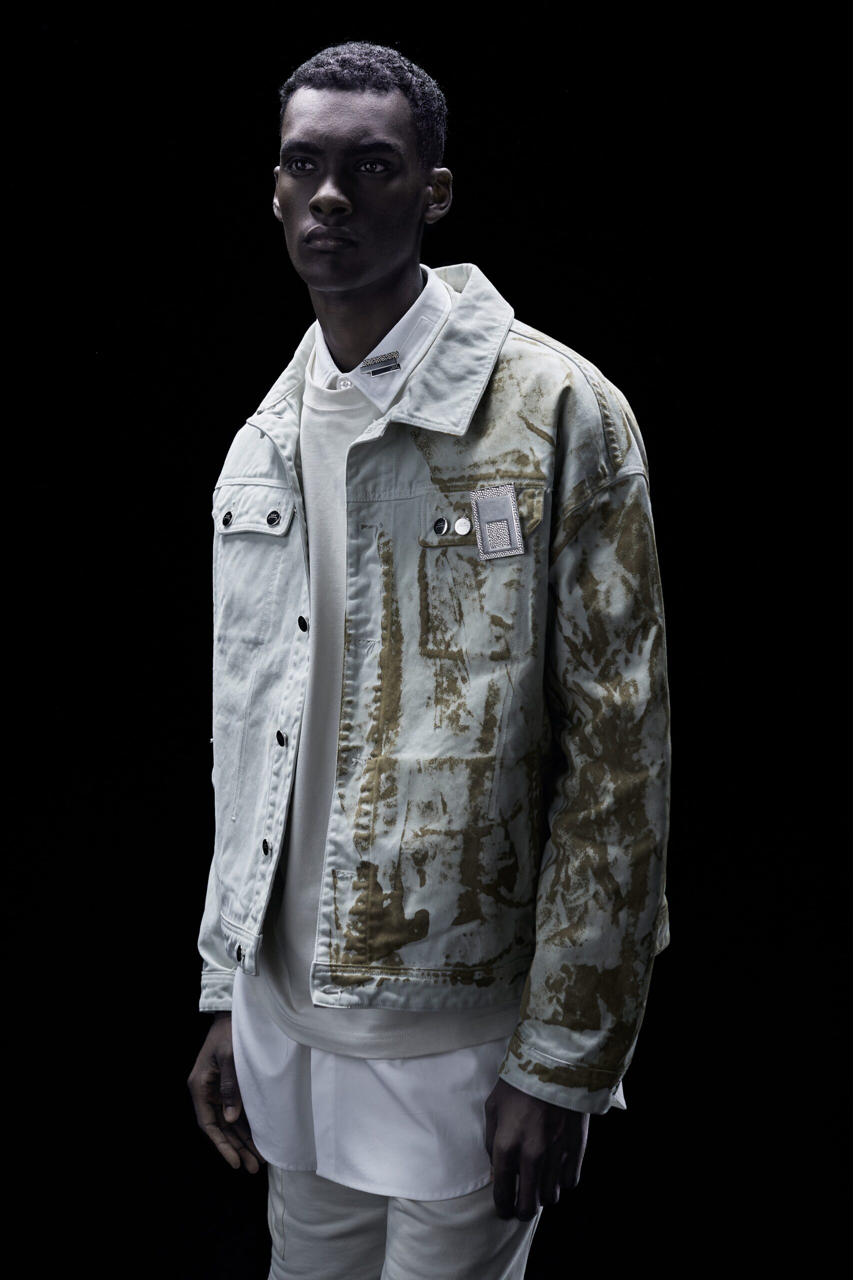 A relaxed gray denim jacket layered over a white collared shirt with button details.