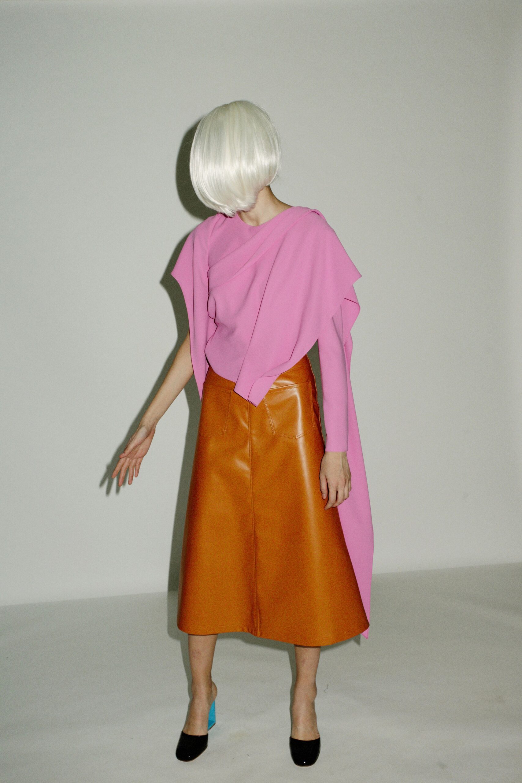 pink draped top and orange pencil skirt
