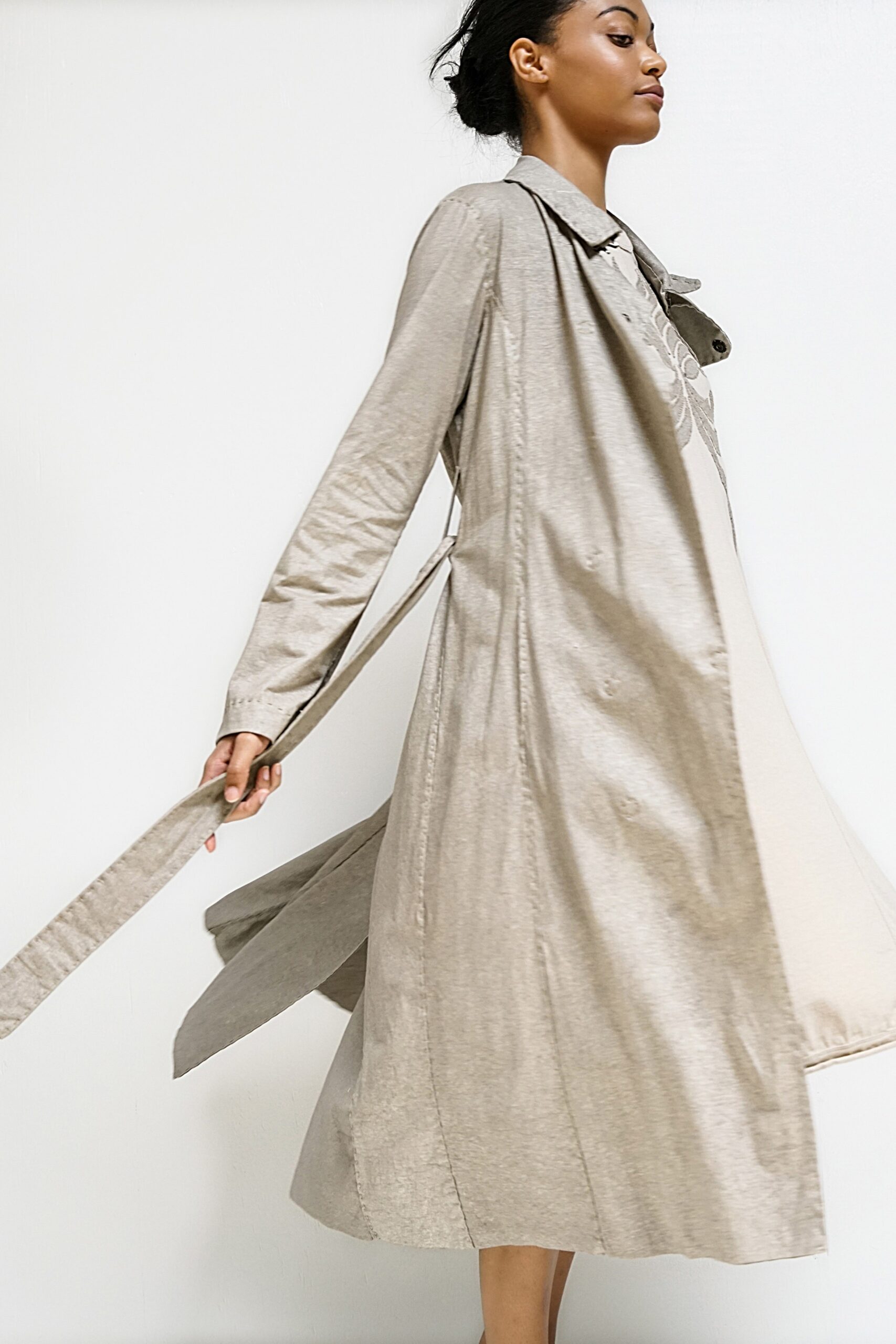 beige cotton trench coat and ivory dress