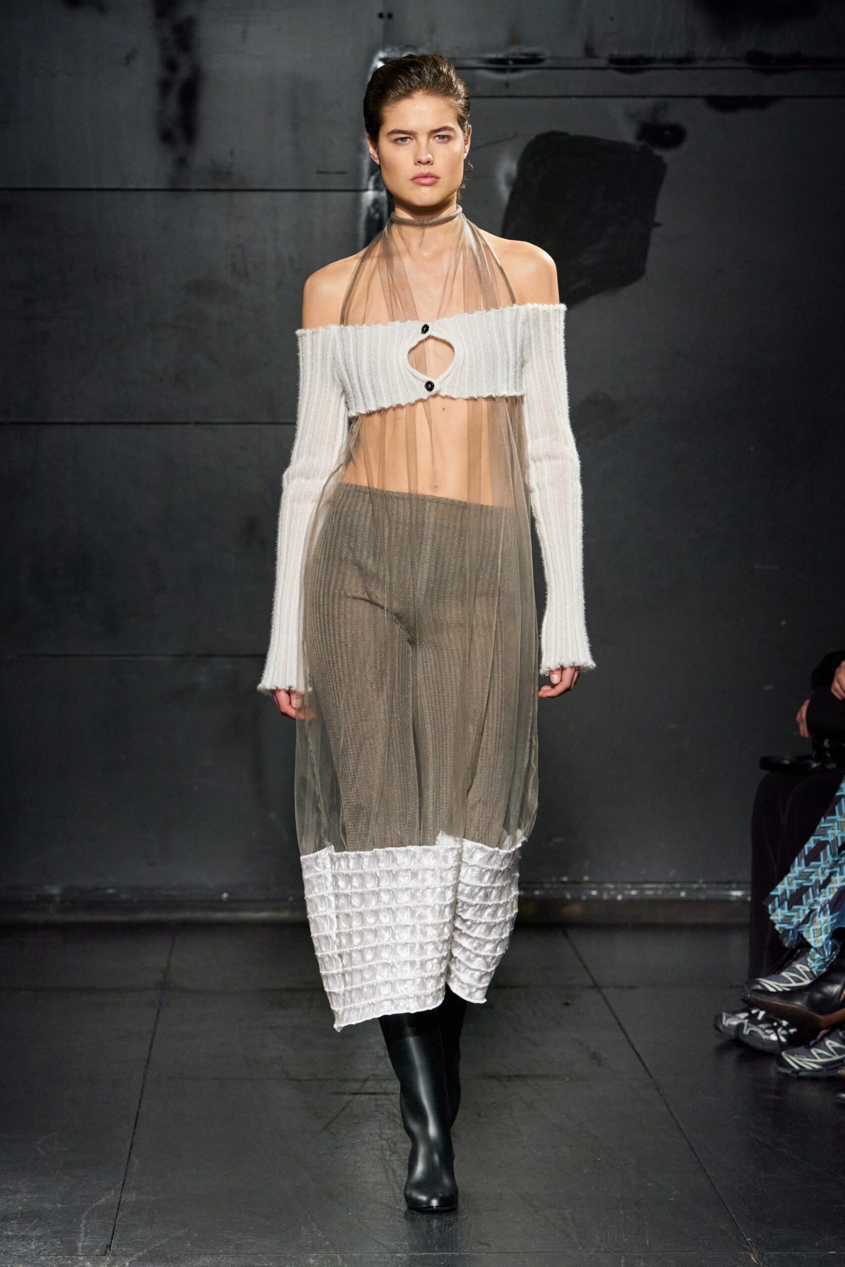 A fitted sheer dress in black and white with a high-neck and asymmetric layered design.