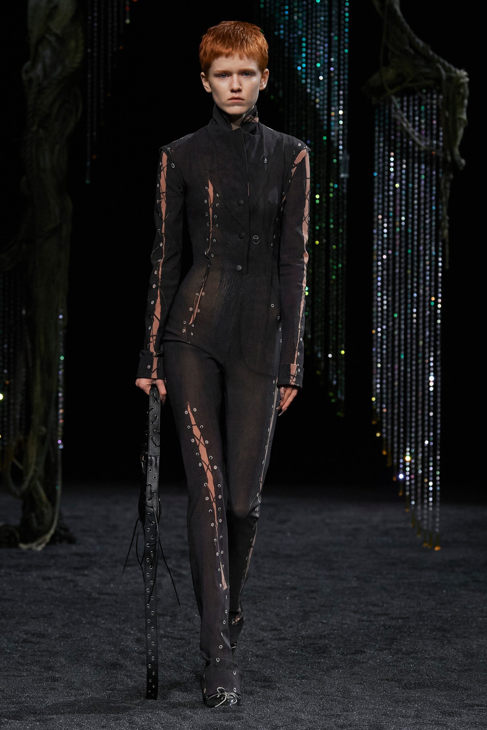 A fitted black silk suit with long sleeves, a collared design, and asymmetric details.