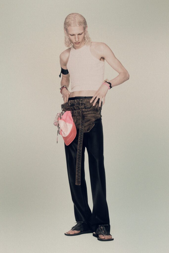 A fitted sleeveless white top paired with high-waisted black denim pants featuring a straight-leg design.