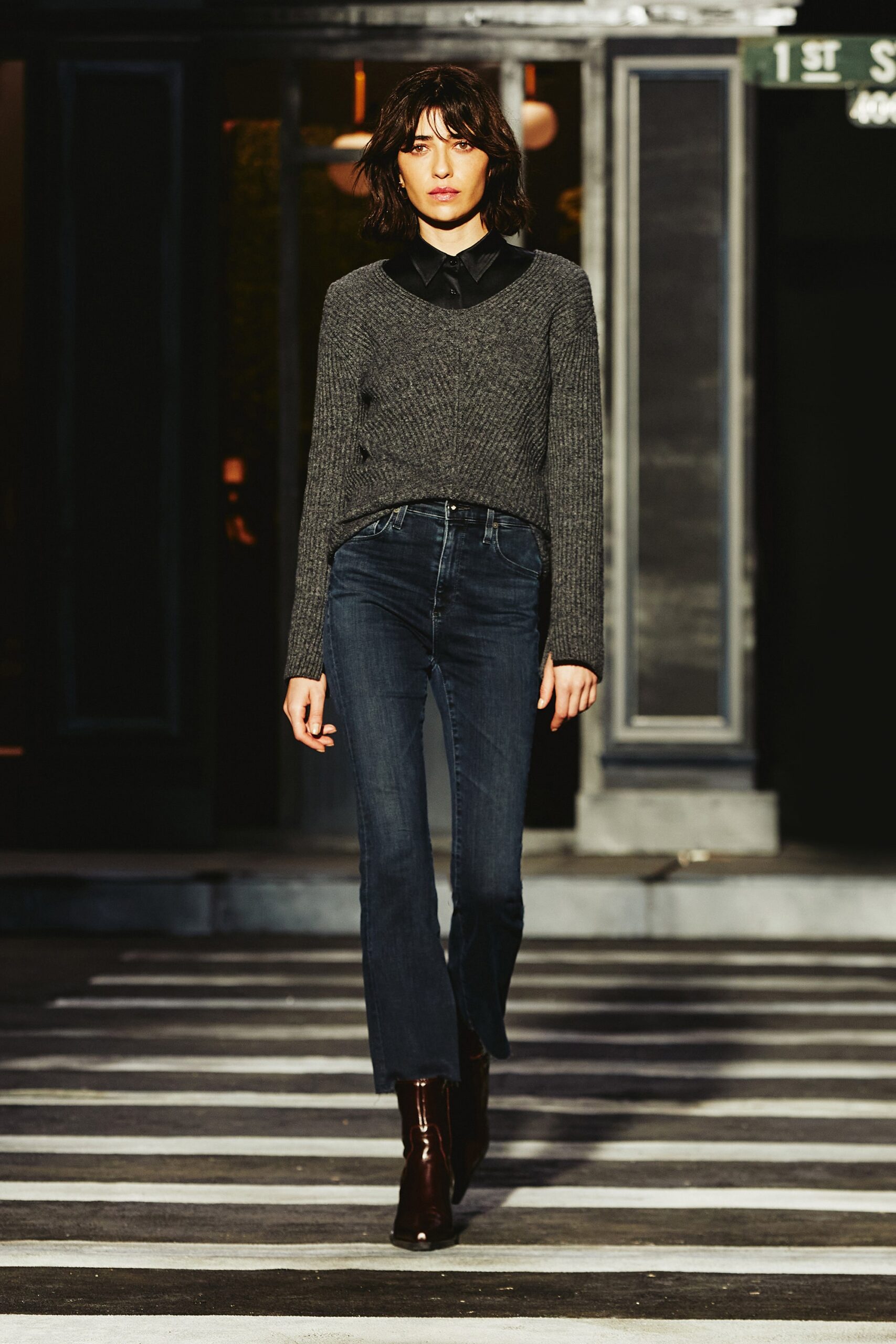 A fitted gray long-sleeve sweater paired with blue straight-leg jeans.