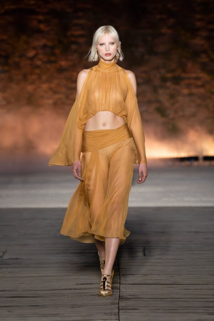 A relaxed yellow silk sleeveless dress with a high neckline and layered design.