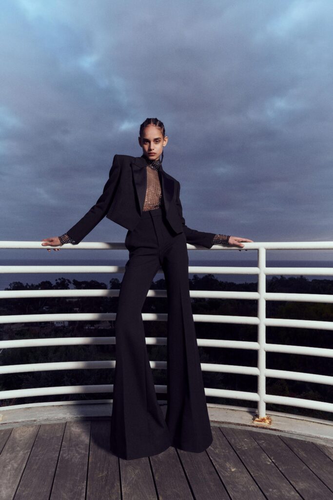 A fitted black cotton suit with long sleeves and a collared design featuring flared pants.