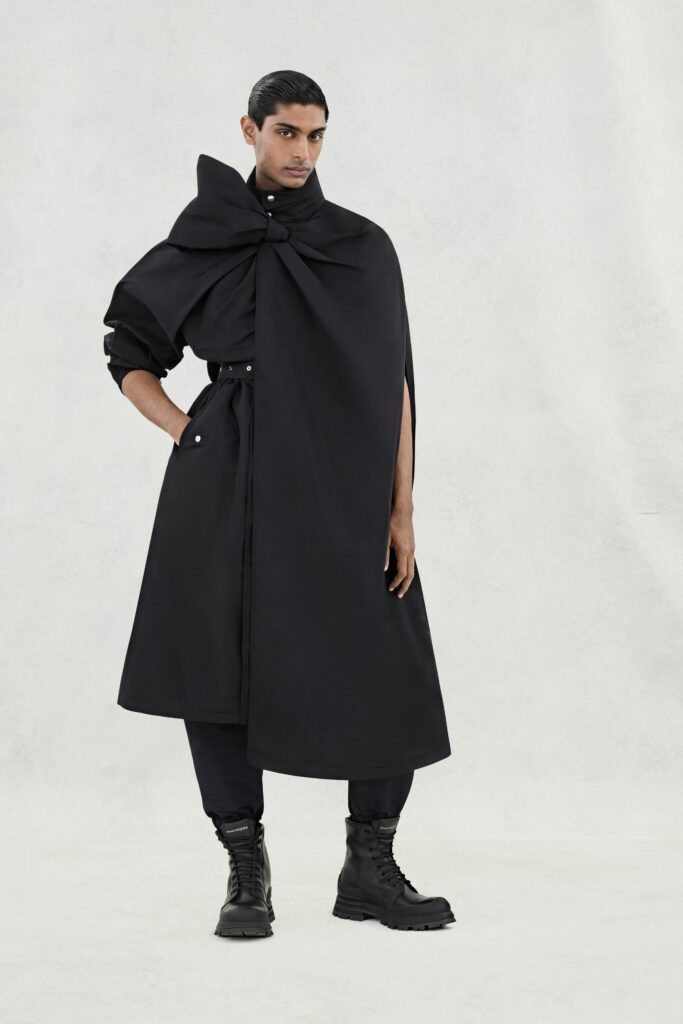 A relaxed black coat with long sleeves and an asymmetric design.