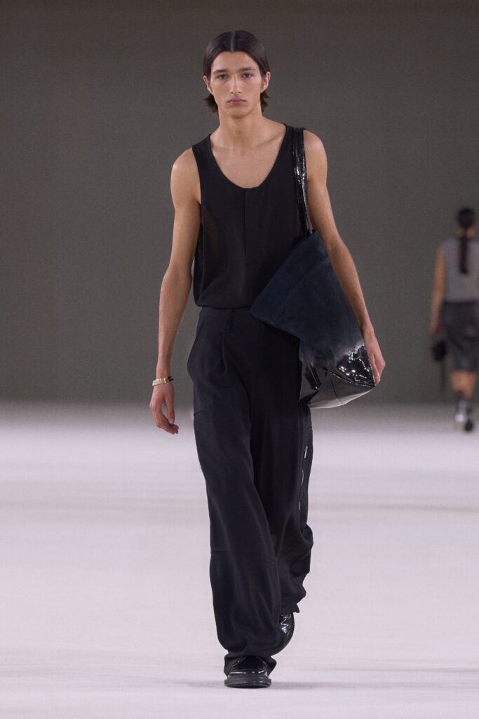 A relaxed black sleeveless top paired with straight-leg black pants for a modern look.