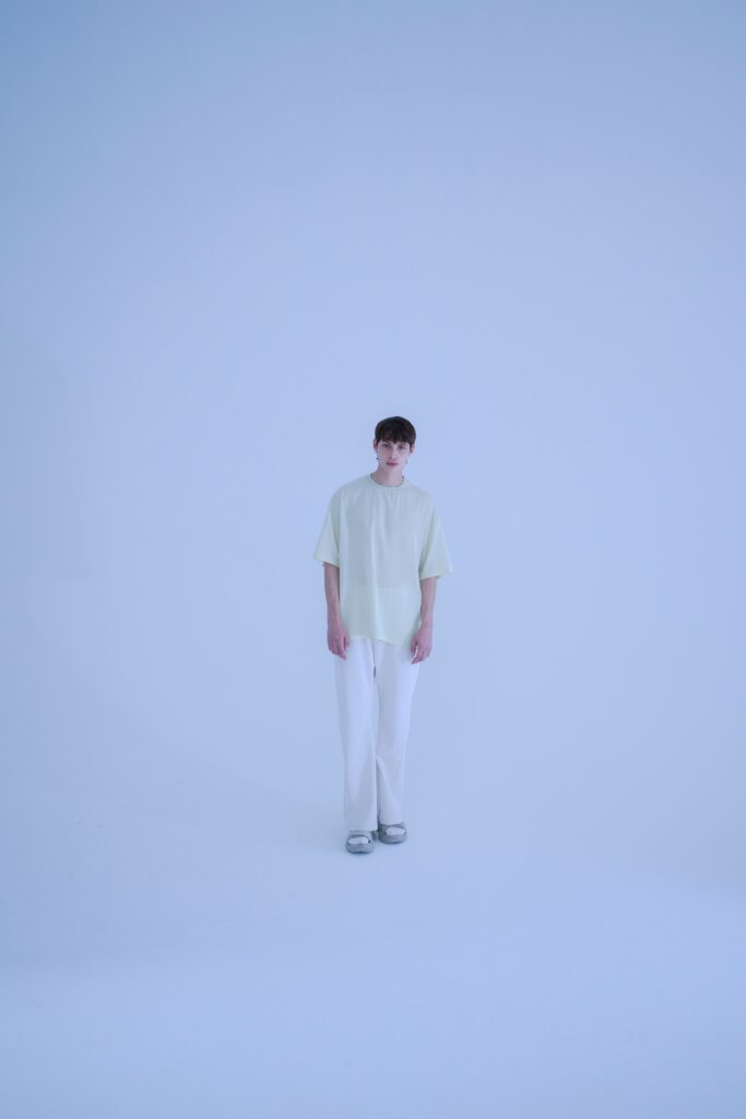A relaxed light yellow short-sleeve top paired with straight-leg white pants.