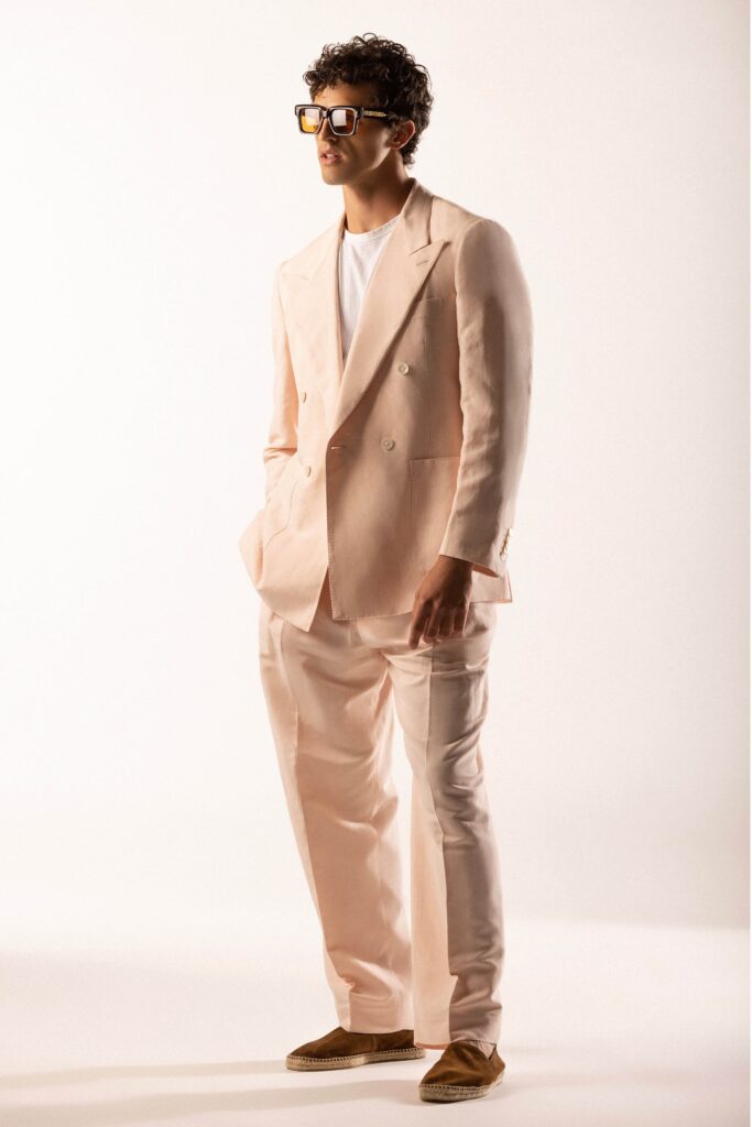 A tailored beige suit with long sleeves and a collared design, featuring buttoned details.