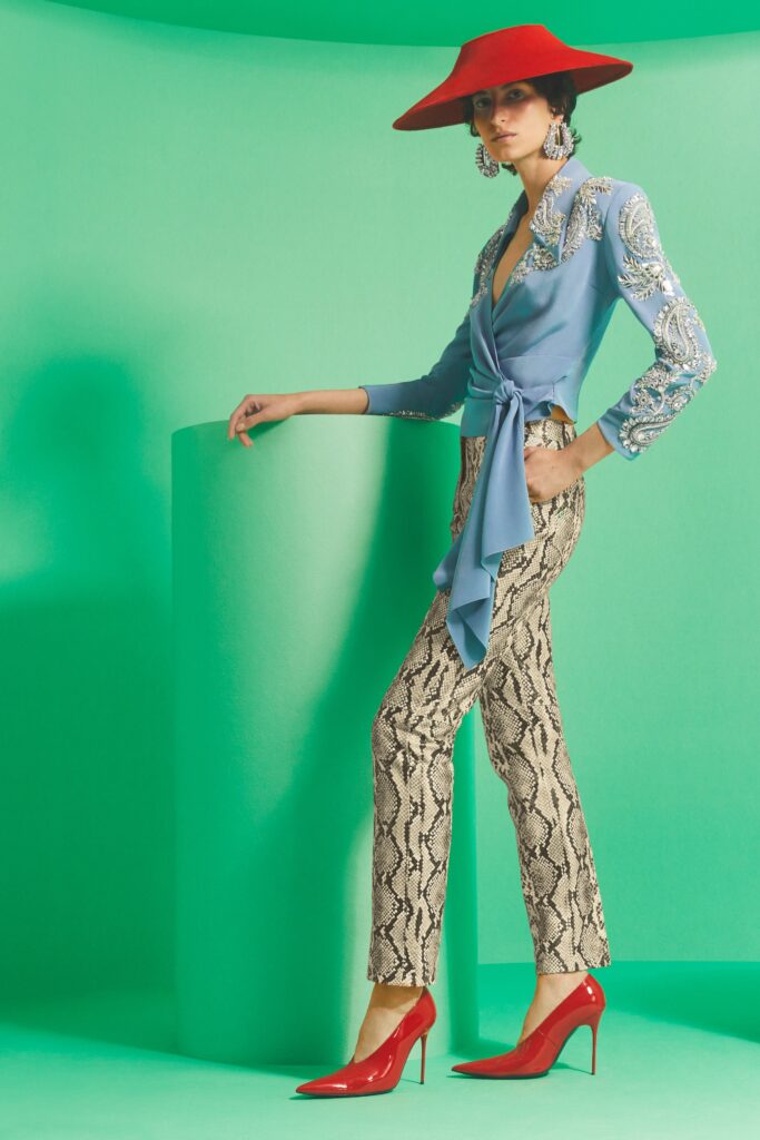 A fitted blue silk long-sleeve shirt with a collar paired with printed beige pants.