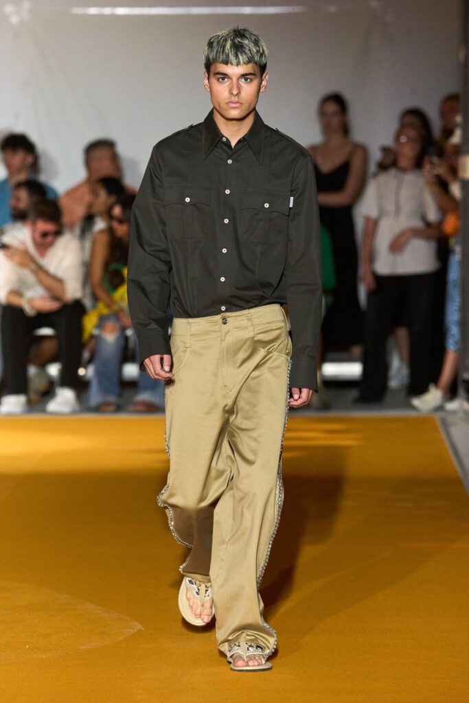 A relaxed black cotton long-sleeve shirt paired with wide-leg beige pants.