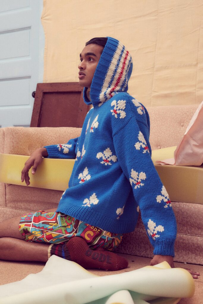 A relaxed blue sweater with a hood and printed shorts, perfect for a casual look.