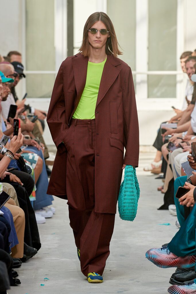 A relaxed brown checked jacket paired with green top and matching pants.