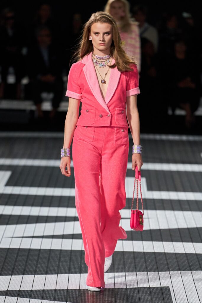 A fitted pink cotton suit with short sleeves, a collared neckline, and wide-leg trousers.