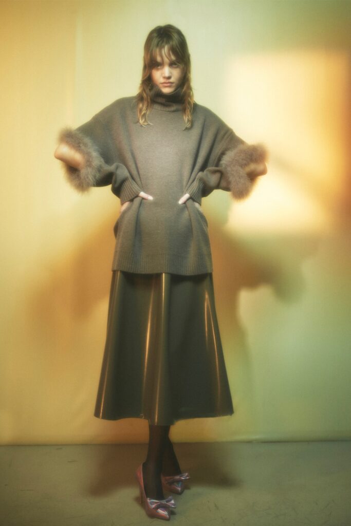 A relaxed gray wool top with short sleeves paired with a pleated metallic skirt.