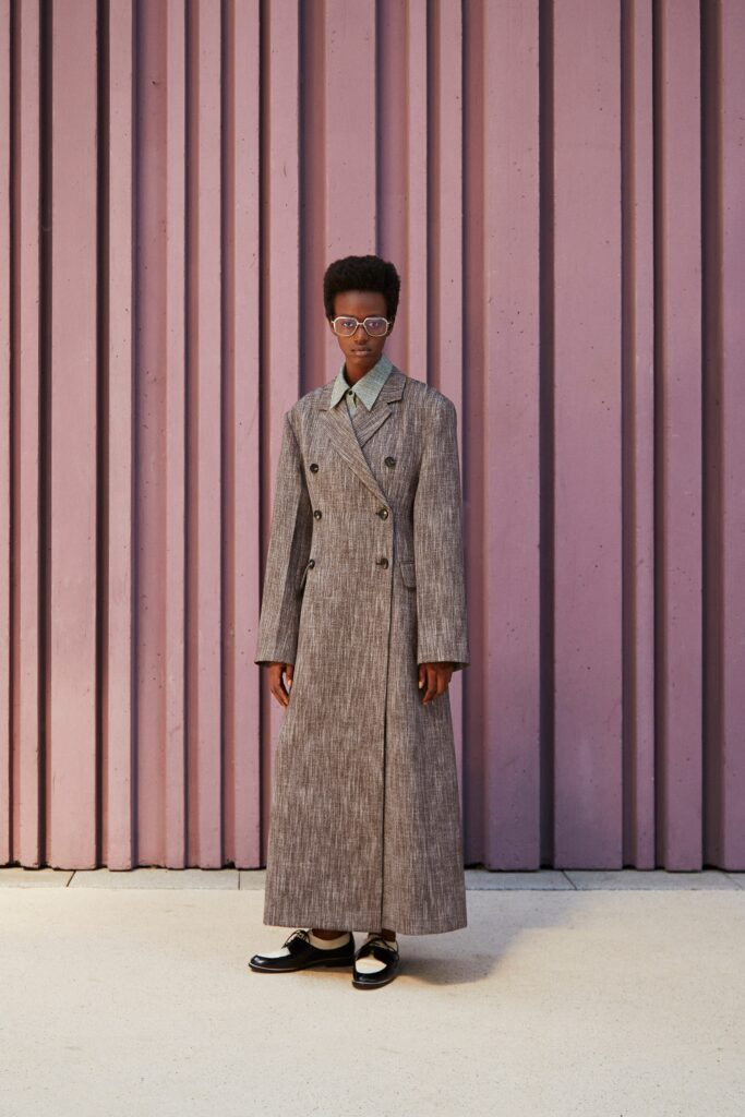 A relaxed gray wool coat with long sleeves and a double-breasted design.
