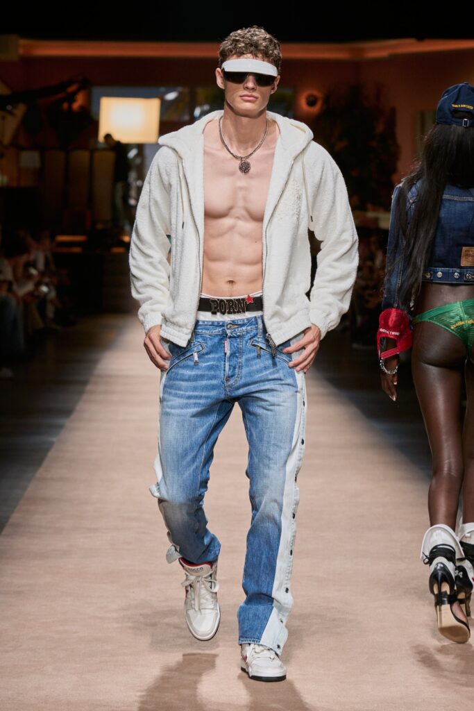 A relaxed white jacket with long sleeves and blue denim pants featuring a buttoned design.