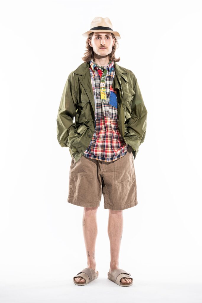 A relaxed green jacket paired with checked shirt and beige shorts for a casual look.