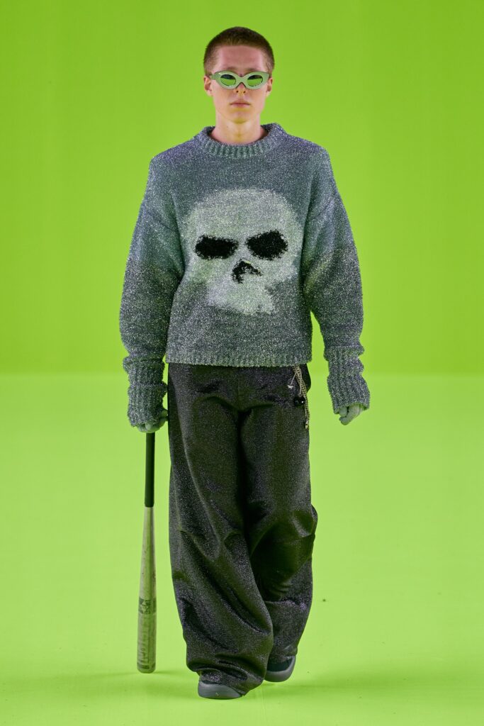 A relaxed gray knit sweater with a printed design paired with relaxed-fit pants.