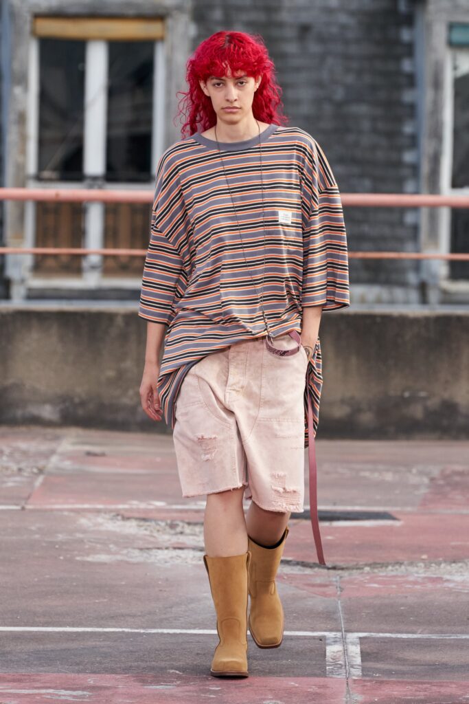A relaxed multicolor striped top with short sleeves paired with distressed beige shorts.