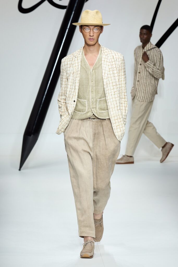 A relaxed beige cotton vest with a collared design paired with wide-leg pants.