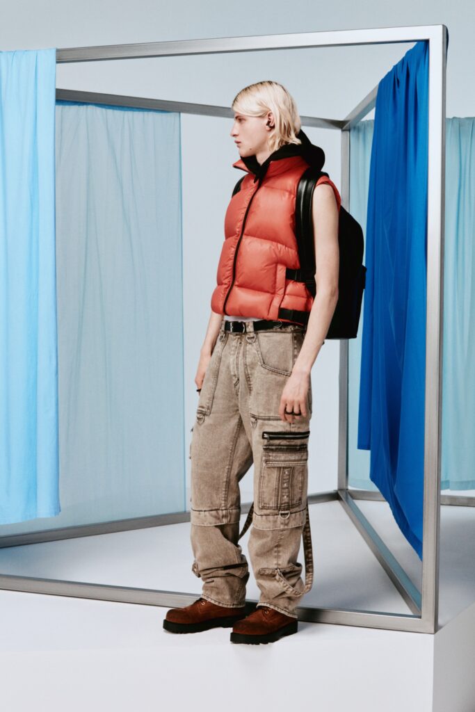 A relaxed red sleeveless vest paired with high-waisted cargo pants in beige.