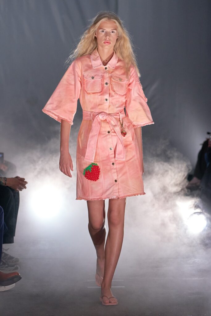 A relaxed pink cotton dress with short sleeves and a collared neckline, featuring a belted design.