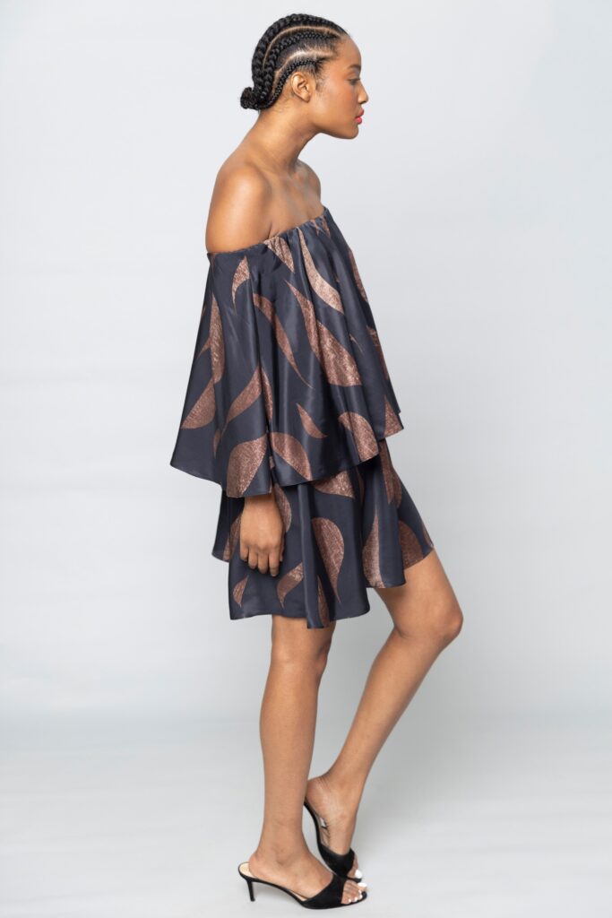 A relaxed black silk off-shoulder dress with a layered design.