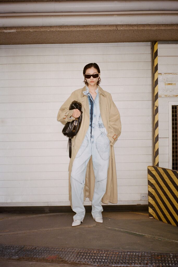 A relaxed-fit beige coat paired with collared denim pants, featuring a buttoned design.