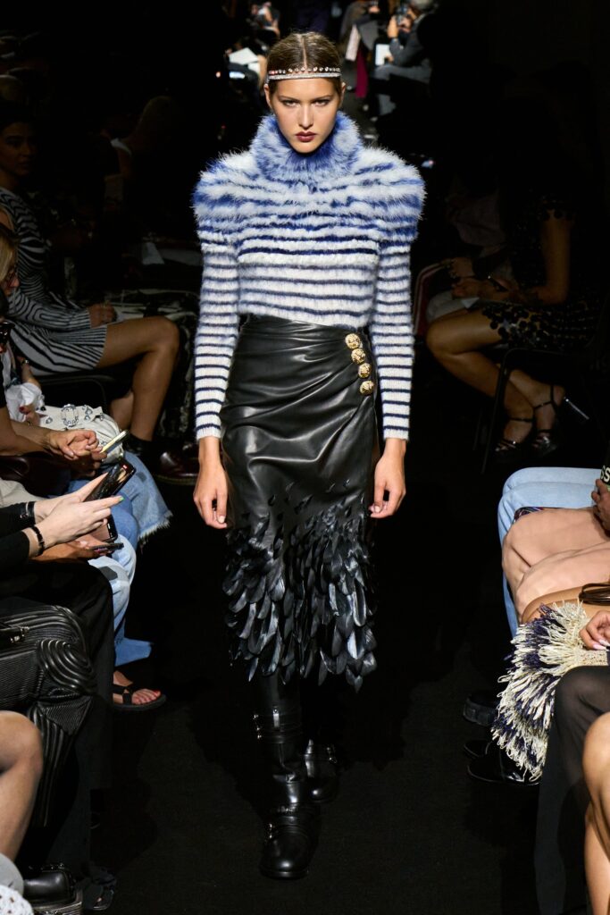 A fitted striped wool top with a high-neck and an asymmetric black leather skirt.