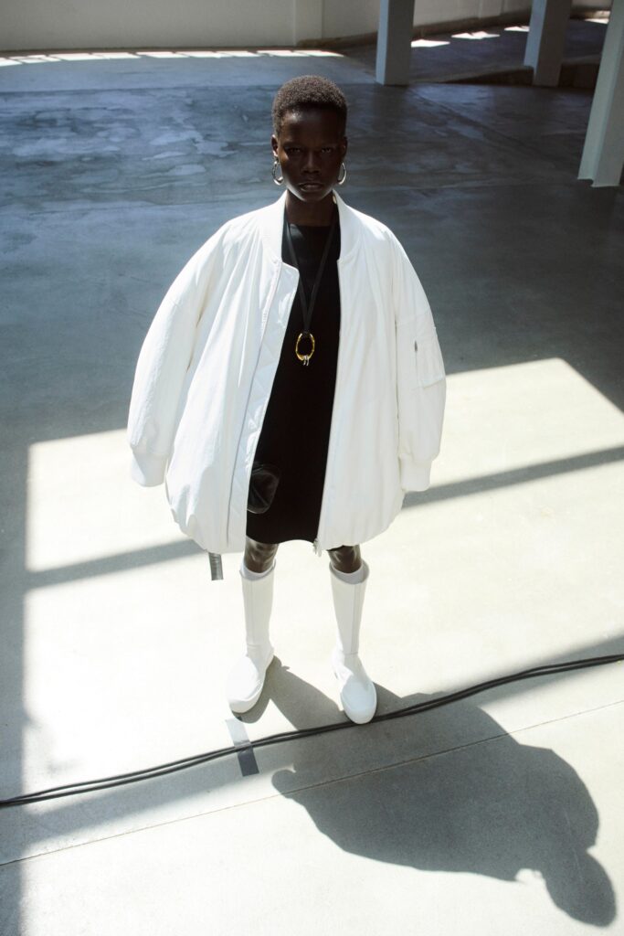 An oversized black dress layered with a white long-sleeve collared jacket.