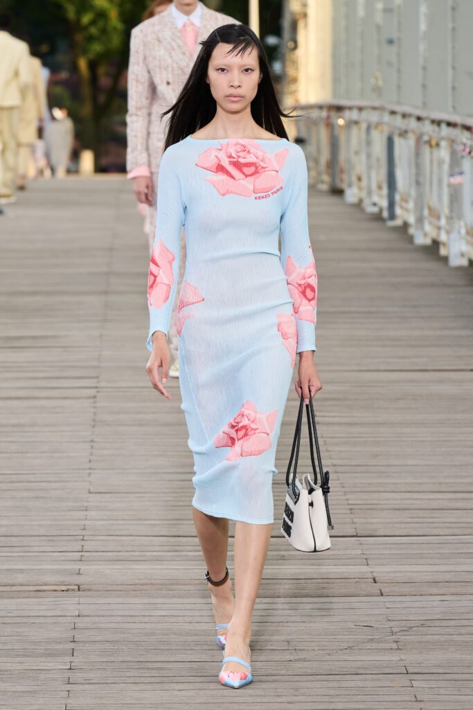A fitted blue dress with long sleeves, a V-neckline, and floral prints.