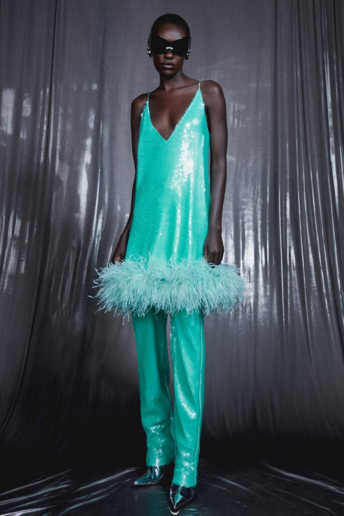 A fitted blue sequin sleeveless dress with a V-neckline and flared pants.