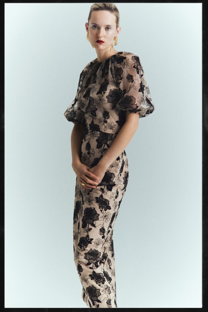 A fitted beige silk dress with short sleeves and an embroidered design.