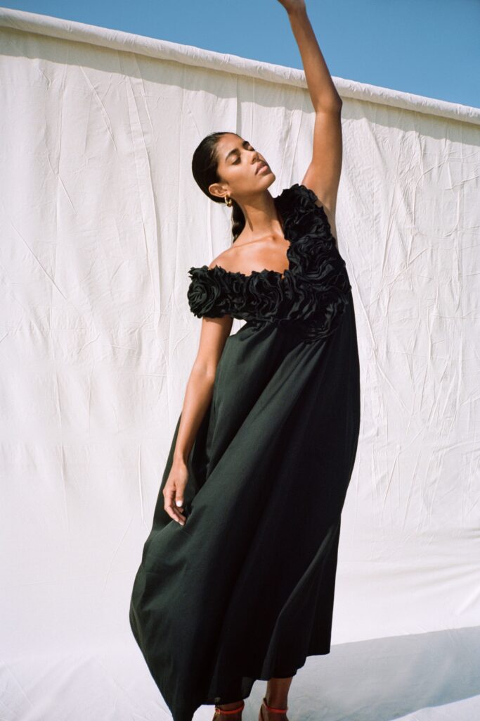 A relaxed black ruffled maxi dress with an off-shoulder design.