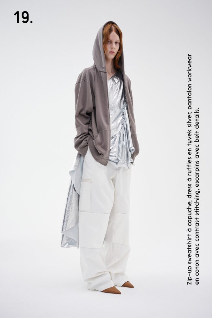 A relaxed gray hoodie with long sleeves paired with layered white pants.