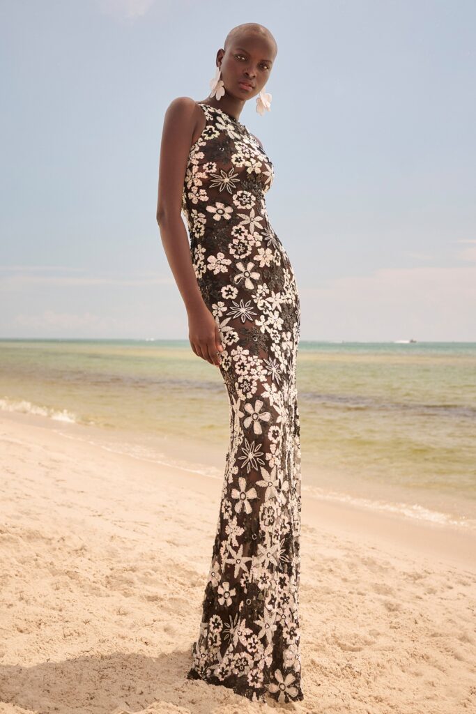 A fitted black and white lace dress with a high neckline and flared silhouette.