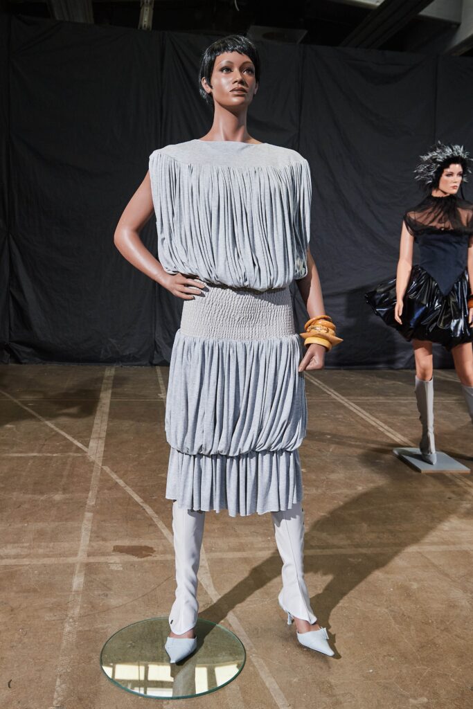 A relaxed gray sleeveless dress with a high neckline and pleated design.