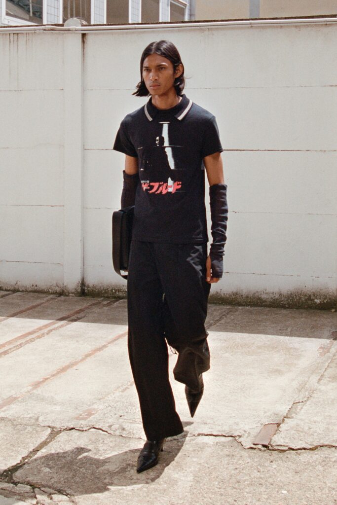 A fitted black t-shirt with a printed design paired with black pants.